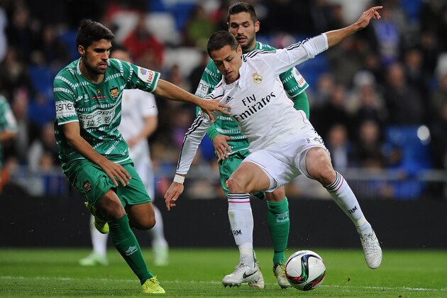 MADRID, SPAIN - DECEMBER 02:  Javier 'Chicharito' Hernandez of Real Madrid is tackled by Carlos Borja of Cornella during the Copa Del Rey Round of 32, Second Leg match between Real Madrid CF and Cornella at Santiago Bernabeu stadium on December 2, 2014 in Madrid, Spain.  (Photo by Denis Doyle/Getty Images)