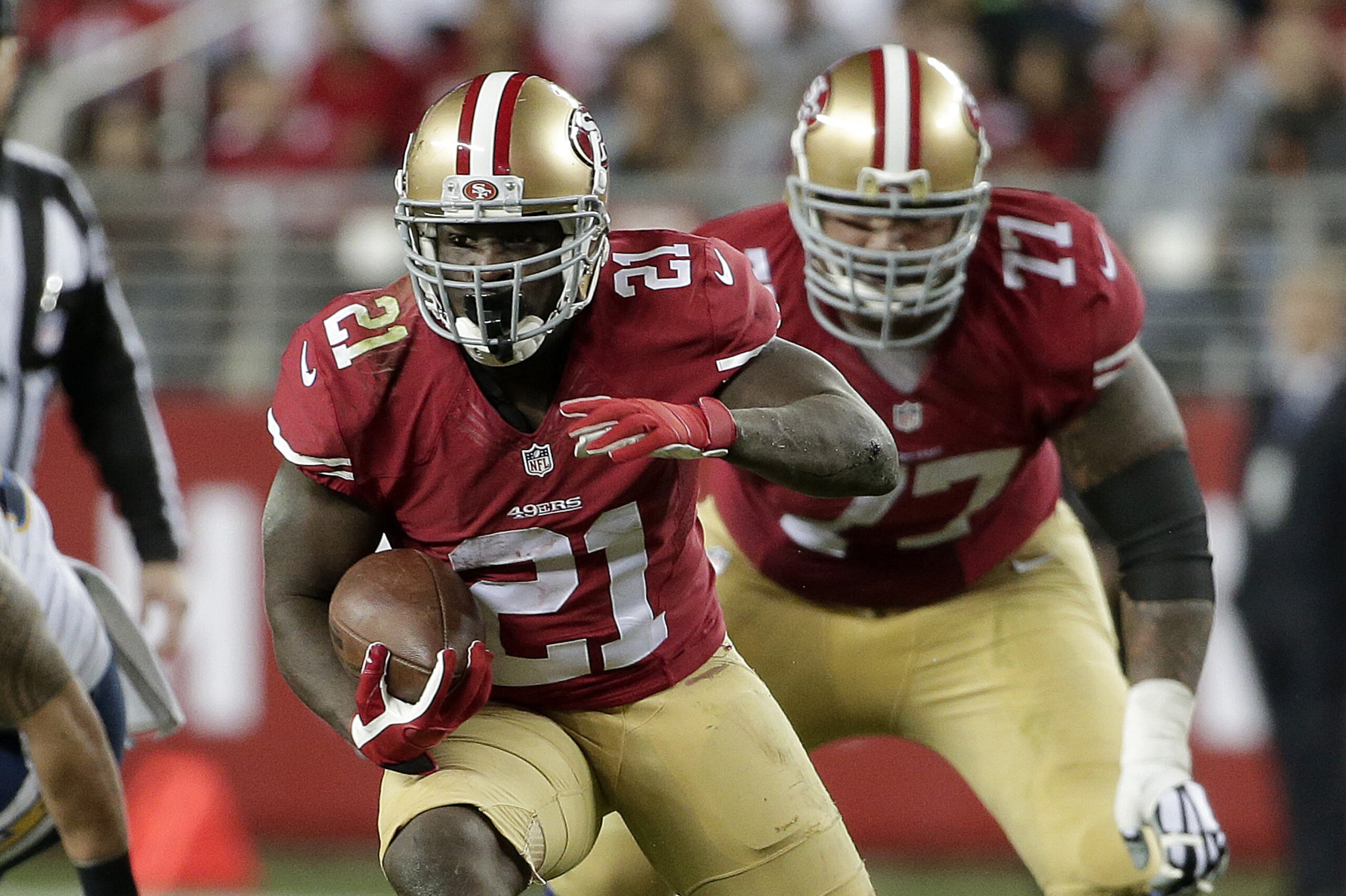 San Francisco 49ers running back Frank Gore (21) runs in front of guard Mike Iupati (77) against the San Diego Chargers during the first half of an NFL football game in Santa Clara, Calif., Saturday, Dec. 20, 2014. (AP Photo/Marcio Jose Sanchez)