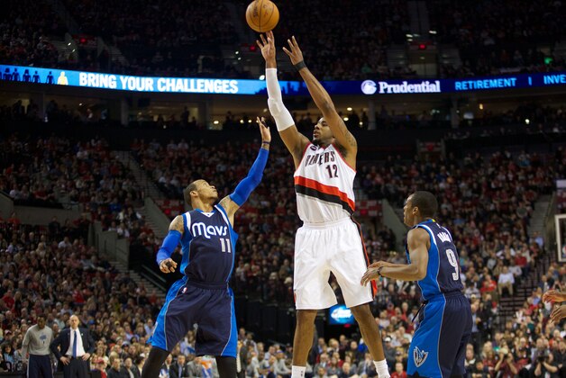 Mar 5, 2015; Portland, OR, USA; Portland Trail Blazers forward LaMarcus Aldridge (12) shoots over Dallas Mavericks guard Monta Ellis (11) and Mavericks guard Rajon Rondo (9) at Moda Center at the Rose Quarter. Mandatory Credit: Jaime Valdez-USA TODAY Sports