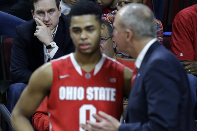 Sam Hinkie, back left, General Manager and President of Basketball Operations of the Philadelphia 76ers, looks on as Ohio State head coach Thad Matta, right talks to guard D'Angelo Russell (0) during the second half of an NCAA college basketball game against Rutgers in Piscataway, N.J., Sunday, Feb. 8, 2015. Ohio State won 79-60. Russell had a triple-double in Ohio State's 79-60 win. (AP Photo/Mel Evans)
