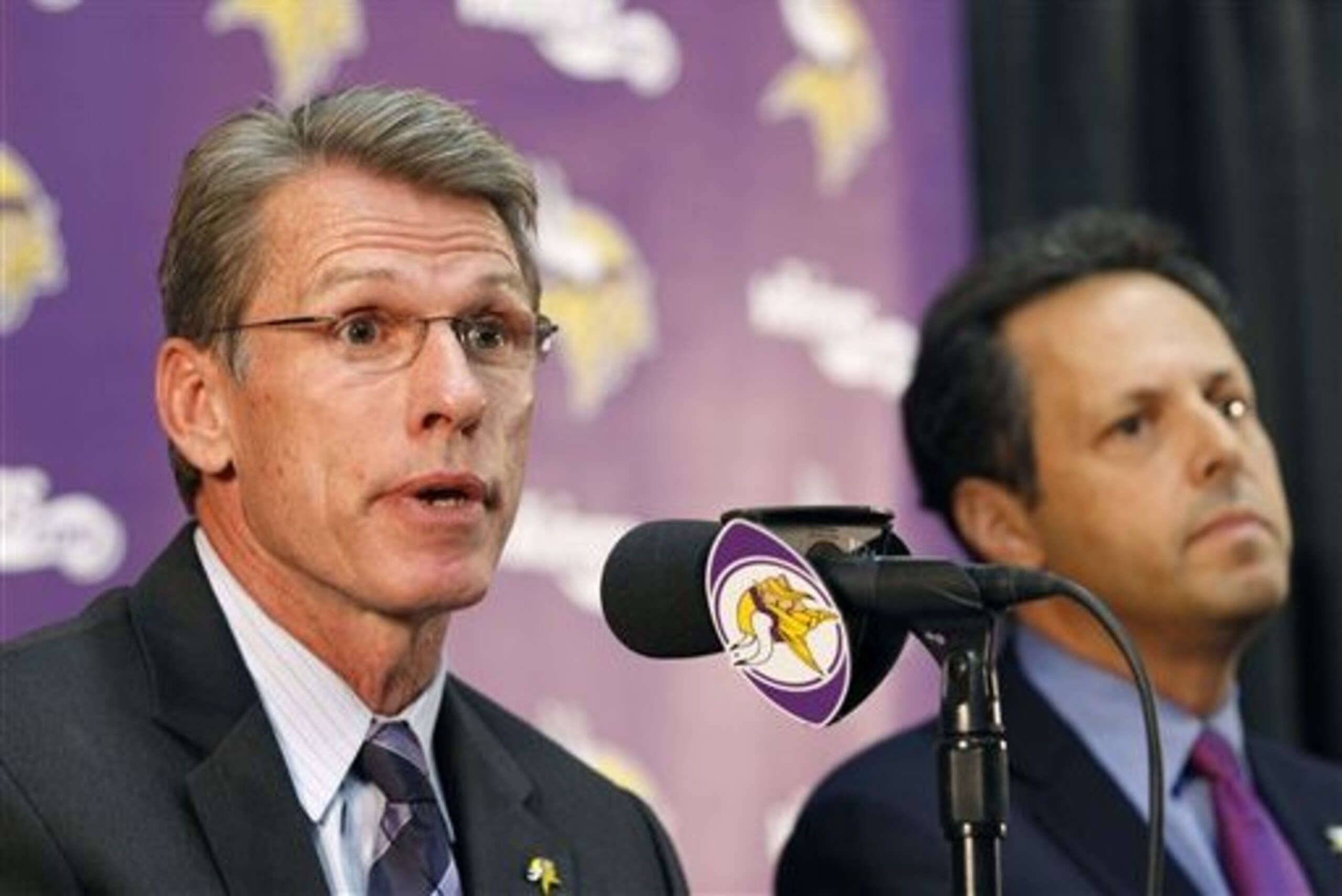 FILE - In this Sept. 17, 2014, file photo, Minnesota Vikings general manager Rick Spielman, left, speaks as owner/chairman Mark Wilf  listens during a news conference in Eden Prairie, Minn. ast offseason, he hired a head coach and drafted the latest candidate for the franchise quarterback. This time the pressure is on the Minnesota Vikings general manager again, with the status of running back Adrian Peterson up in the air. (AP Photo/Ann Heisenfelt, File)