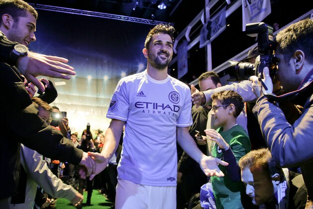 Spanish soccer star David Villa is greeted by fans as he walks down the aisle wearing the jersey to be worn by players on Major League Soccer's new team, the New York City Football Club, during an introductory celebration,  Thursday, Nov. 13, 2014, in New York. New York City FC will play its first game at Yankee Stadium in March. (AP Photo/Julie Jacobson)