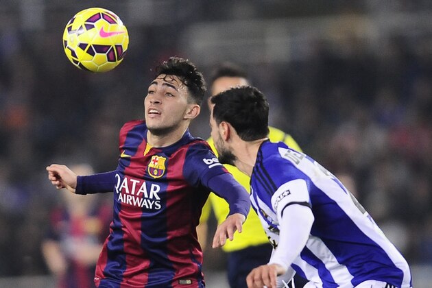 Barcelona's Munir El Haddadi, left, duels for the ball with Real Sociedad's Alberto De La Bella, during their La Liga soccer match, at Anoeta stadium in San Sebastian, northern Spain, Sunday, Jan. 4, 2015. (AP Photo/Alvaro Barrientos)