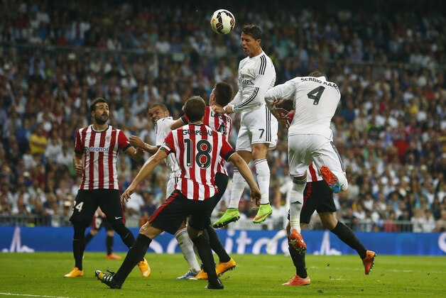 Real's Cristiano Ronaldo, top, hits the ball as he tries to score in between players during a Spanish La Liga soccer match between Real Madrid and Athletic Bilbao at the Santiago Bernabeu stadium in Madrid, Spain, Sunday, Oct. 5, 2014. (AP Photo/Andres Kudacki)