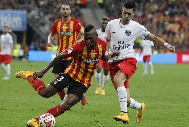 Lens Dimitri Cavare, left, and PSG's Argentinian Javier Pastore, right, challenge for the ball during their League One soccer match Lens against Paris Saint Germain at Stade de France stadium in Saint Denis, outside Paris, France, Friday, Oct. 17, 2014. (AP Photo/Michel Euler)