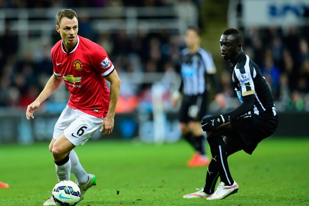 NEWCASTLE UPON TYNE, ENGLAND - MARCH 04:  Manchester United player Jonny Evans (l) in action as Papiss Cisse of Newcastle looks on during the Barclays Premier League match between Newcastle United and Manchester United at St James' Park on March 4, 2015 in Newcastle upon Tyne, England.  (Photo by Stu Forster/Getty Images)