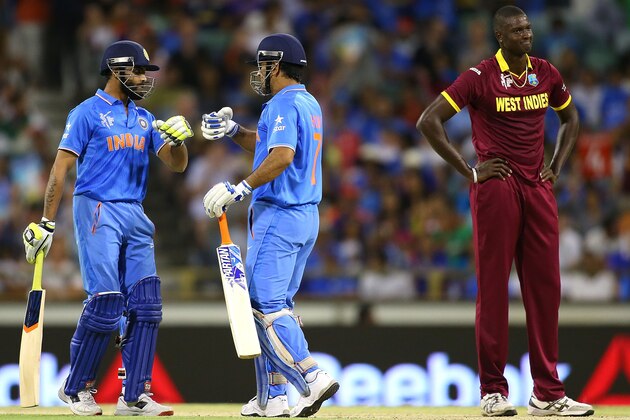 PERTH, AUSTRALIA - MARCH 06: Ravindra Jadeja and MS Dhoni of India celebrate a boundary as Jason Holder of the West Indies looks on during the 2015 ICC Cricket World Cup match between India and the West Indies at WACA on March 6, 2015 in Perth, Australia.  (Photo by Paul Kane/Getty Images)