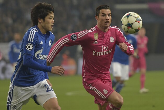 Schalke's Atsuto Uchida, left, fights for the ball with Real Madrid's Cristiano Ronaldo during the Champions League round of 16 first leg soccer match between FC Schalke 04 and Real Madrid in Gelsenkirchen, Germany on Wednesday, Feb. 18, 2015. (AP Photo/Martin Meissner)
