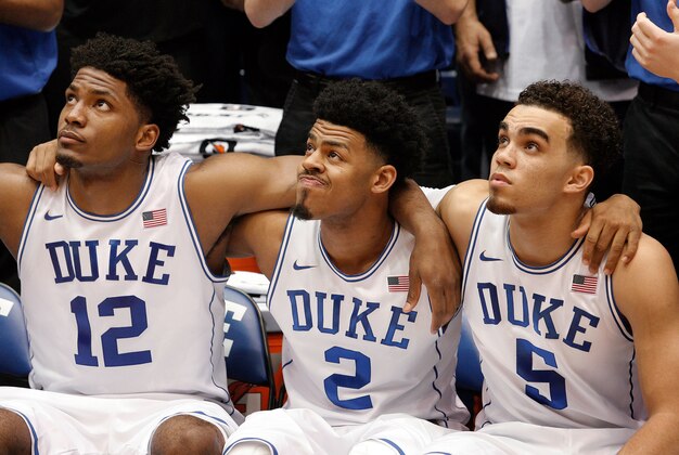 Mar 4, 2015; Durham, NC, USA; Duke Blue Devils forward Justise Winslow (12) and guard Quinn Cook (2) and guard Tyus Jones (5) watch the promo video before player introductions before their game against the Wake Forest Demon Deacons at Cameron Indoor Stadium. Mandatory Credit: Mark Dolejs-USA TODAY Sports