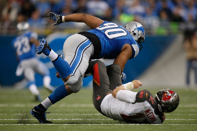 DETROIT, MI - DECEMBER 07: Ndamukong Suh #90 of the Detroit Lions sacks a Josh McCown #12 of the Tampa Bay Buccaneers. Ndamukong Suh #90 was given a penalty for roughing the passer at Ford Field on December 07, 2014 in Detroit, Michigan. (Photo by Gregory Shamus/Getty Images)