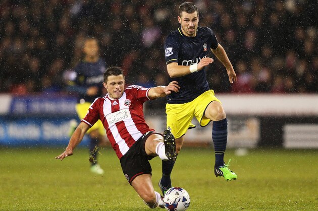 SHEFFIELD, ENGLAND - DECEMBER 16:  Morgan Schneiderlin of Southampton is tackled by Florent Cuvelier of Sheffield United during the Capital One Cup Quarter-Final match between Sheffield United and Southampton at Bramall Lane on December 16, 2014 in Sheffield, England.  (Photo by Clive Mason/Getty Images)