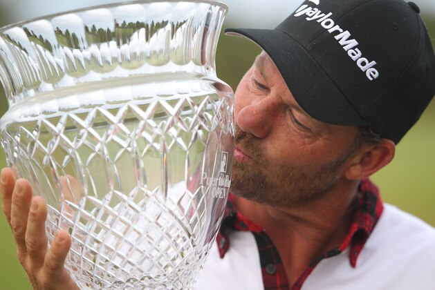Alex Cejka kisses his trophy after winning the Puerto Rico Open in Rio Grande, Puerto Rico, Sunday, March 8, 2015, the 44-year-old Czech-born German's first PGA Tour title. (AP Photo/Ricardo Arduengo)