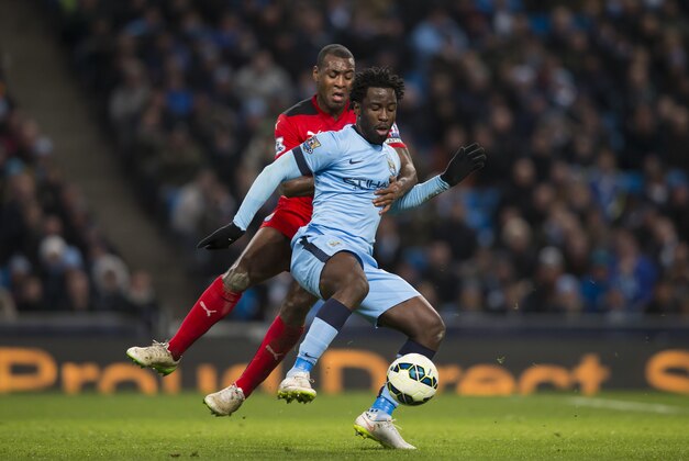 Manchester City's Wilfried Bony, centre right, fights for the ball against Leicester's Wes Morgan during the English Premier League soccer match between Manchester City and Leicester City at the Etihad Stadium, Manchester, England, Wednesday March 4, 2015. (AP Photo/Jon Super)