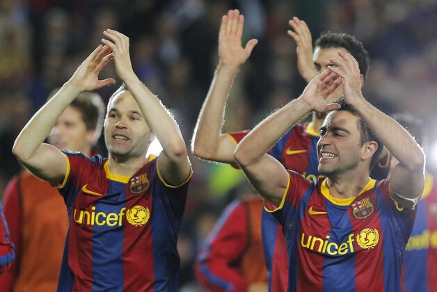 FC Barcelona's Andres Iniesta, left, and Xavi Hernandez, right,  celebrates during a semi final, 2nd leg Champions League soccer match against  Real Madrid at the Camp Nou stadium in Barcelona on Tuesday, May 3, 2011. (AP Photo/Andres Kudacki)