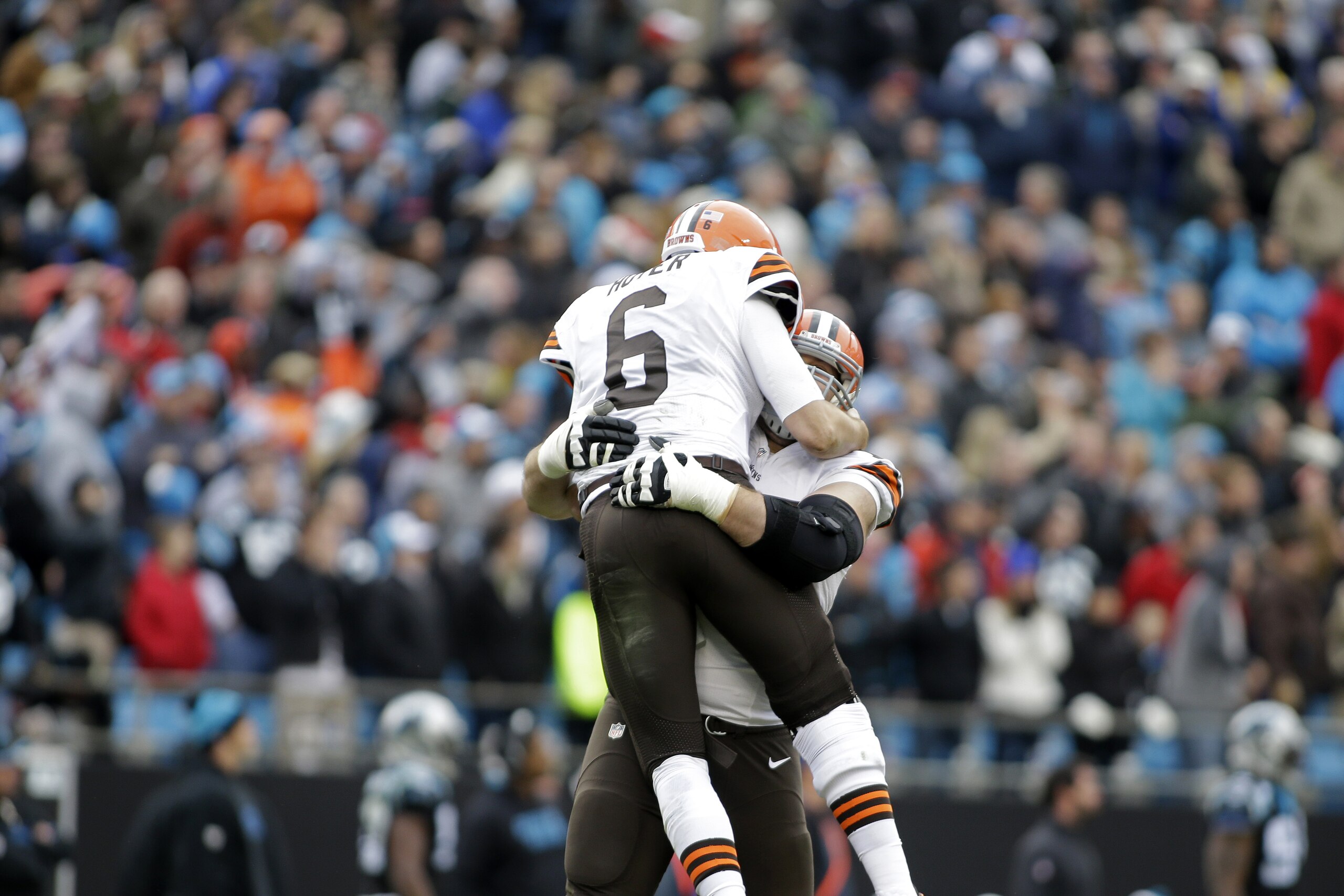 Cleveland Browns' Brian Hoyer (6) jumps into the arms of a teammate after throwing a touchdown pass against the Carolina Panthers in the second half of an NFL football game in Charlotte, N.C., Sunday, Dec. 21, 2014. The Panthers won 17-13. (AP Photo/Bob Leverone)