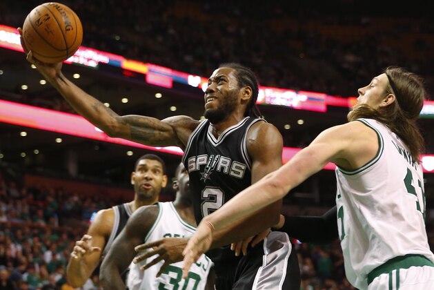 San Antonio Spurs' Kawhi Leonard drives to the basket past Boston Celtics' Kelly Olynyk during an NBA basketball game in Boston Sunday, Nov. 30, 2014. (AP Photo/Winslow Townson)