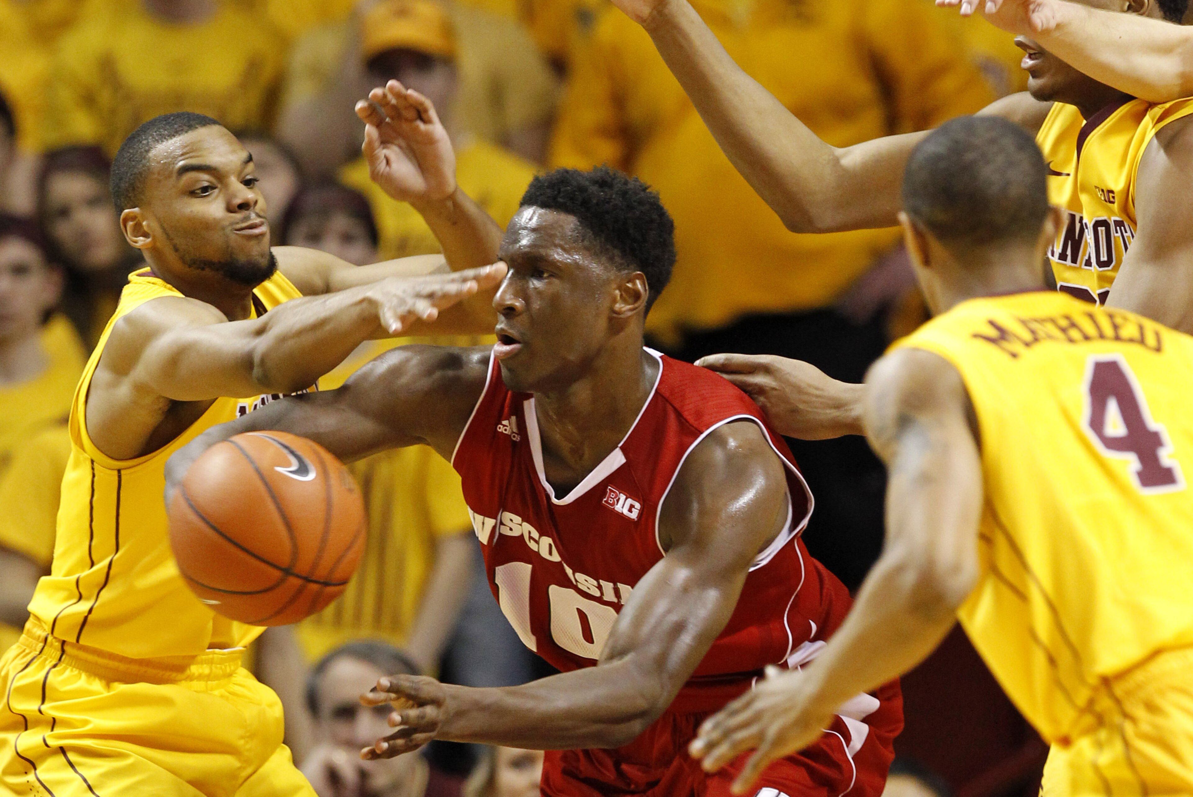 Wisconsin forward Nigel Hayes, center, passes the ball under pressure from Minnesota guard Andre Hollins, left, and others during the second half of an NCAA college basketball game in Minneapolis, Thursday, March 5, 2015. Wisconsin won 76-63. (AP Photo/Ann Heisenfelt)