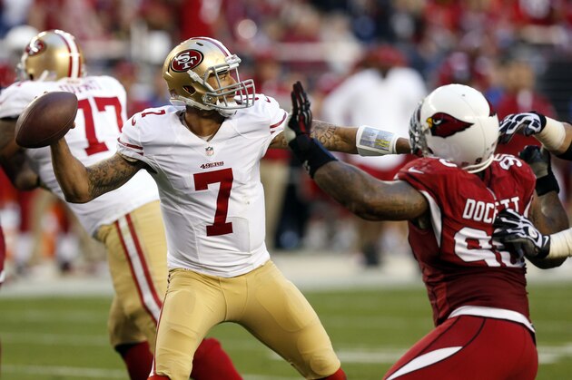San Francisco 49ers quarterback Colin Kaepernick (7) throws under pressure from Arizona Cardinals defensive end Darnell Dockett (90) during the second half of an NFL football game, Sunday, Dec. 29, 2013, in Glendale, Ariz. The 49ers won 23-20.  (AP Photo/Ross D. Franklin)