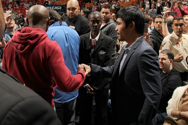 MIAMI, FL - JANUARY 27:  Boxers, Manny Pacquiao and Floyd Mayweather Jr talk before the game between the Milwaukee Bucks and Miami Heat on January 27, 2015 at American Airlines Arena in Miami, Florida. NOTE TO USER: User expressly acknowledges and agrees that, by downloading and or using this Photograph, user is consenting to the terms and conditions of the Getty Images License Agreement. Mandatory Copyright Notice: Copyright 2015 NBAE (Photo by Issac Baldizon/NBAE via Getty Images)