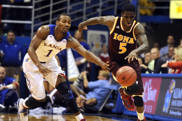 Nov 19, 2013; Lawrence, KS, USA; Iona Gaels guard A.J. English (5) dribbles past Kansas Jayhawks guard Wayne Selden, Jr. (1) in the second half at Allen Fieldhouse. Kansas won the game 86-66. Mandatory Credit: John Rieger-USA TODAY Sports
