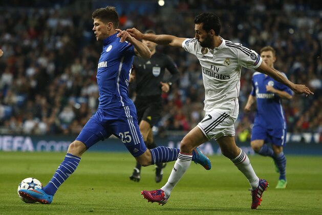 Schalke's Klaas-Jan Huntelaar, left, fights for the ball against Real Madrid's Alvaro Arbeloa during a Champions League soccer match round of 16 second leg, between Real Madrid and Schalke 04 at Santiago Bernabeu stadium, in Madrid, Spain, Tuesday, March 10, 2015. (AP Photo/Andres Kudacki)