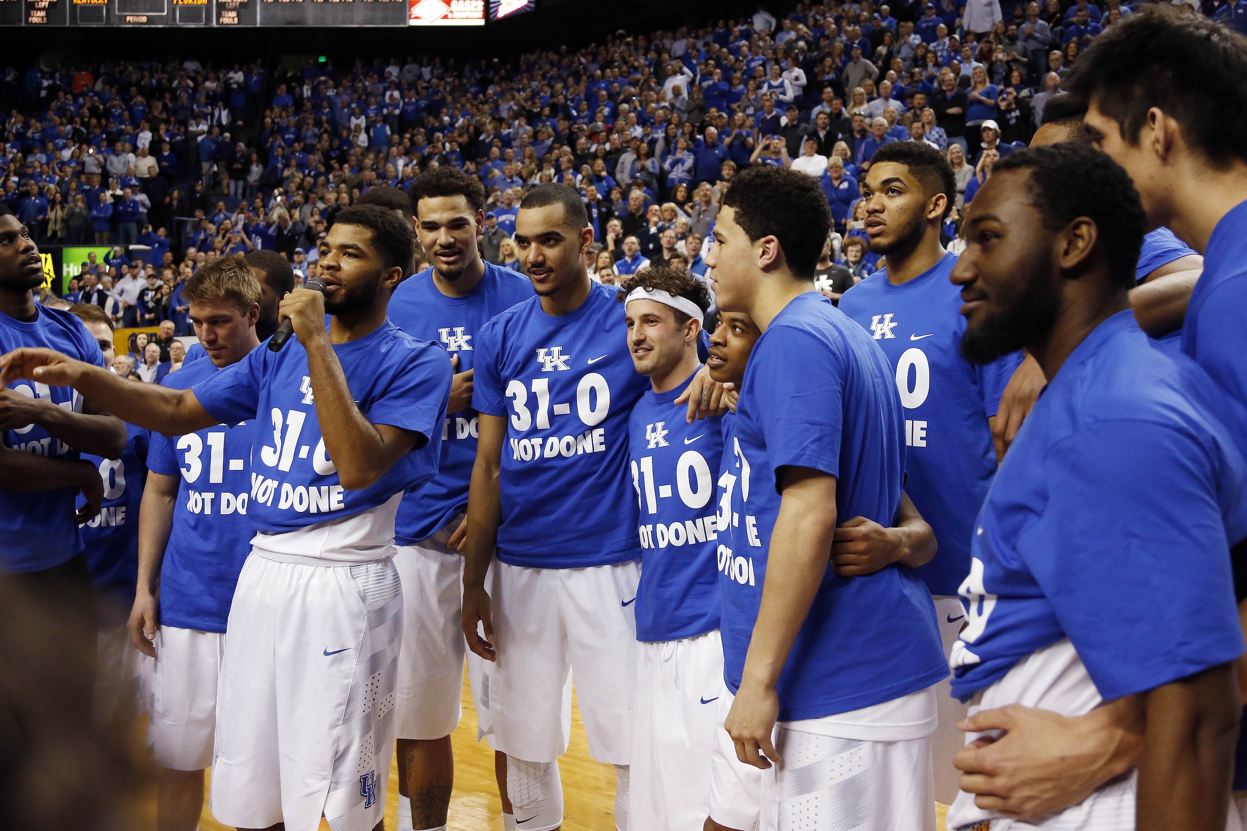 Kentucky Aaron Harrison, with microphone, addresses the crowd during a ceremony marking the teams undefeated regular season after an NCAA college basketball game against Florida, Saturday, March 7, 2015, in Lexington, Ky. Kentucky won 67-50. (AP Photo/James Crisp)