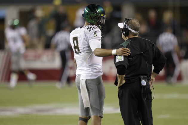 Oregon head coach Chip Kelly, right, talk with quarterback Marcus Mariota, left, during an NCAA college football game against Washington State, Saturday, Sept. 29, 2012, in Seattle. (AP Photo/Ted S. Warren)