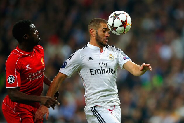 MADRID, SPAIN - NOVEMBER 04:  Karim Benzema of Real Madrid CF heads the ball under pressure from Kolo Toure of Liverpool during the UEFA Champions League Group B match between Real Madrid CF and Liverpool FC at Estadio Santiago Bernabeu on November 4, 2014 in Madrid, Spain.  (Photo by Gonzalo Arroyo Moreno/Getty Images)