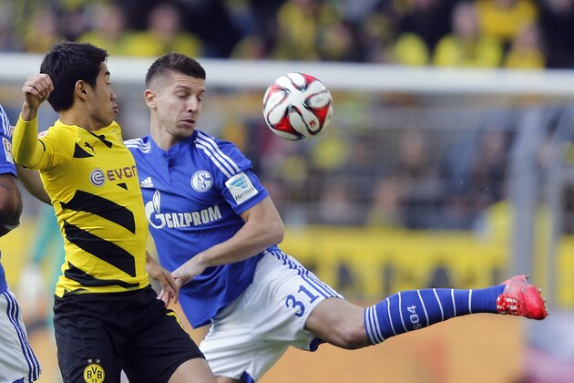 Dortmund’s Shinji Kagawa from Japan, left, and Schalke’s Matija Nastasic from Serbia challenge for the ball during the German first division Bundesliga soccer match between BvB Borussia Dortmund  and Schalke 04 in Dortmund, Germany, Saturday, Feb. 28, 2015. (AP Photo/Frank Augstein)