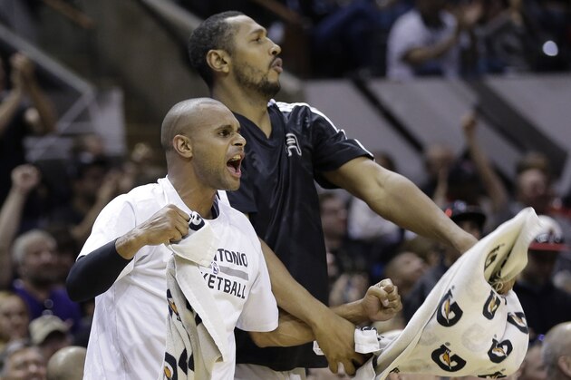 San Antonio Spurs' Patty Mills, left, of Australia, and Boris Diaw, right, of France, cheer for teammate Marco Belinelli as he scores against the Utah Jazz during the second half of an NBA basketball game, Sunday, March 16, 2014, in San Antonio. San Antonio won 122-104. (AP Photo/Eric Gay)