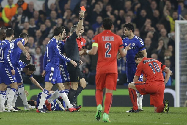 Referee Bjorn Kuipers shows a red card to PSG's Zlatan Ibrahimovic, right,  during the Champions League round of 16 second leg soccer match between Chelsea and Paris Saint Germain at Stamford Bridge stadium in London, Wednesday, March 11, 2015. (AP Photo/Matt Dunham)
