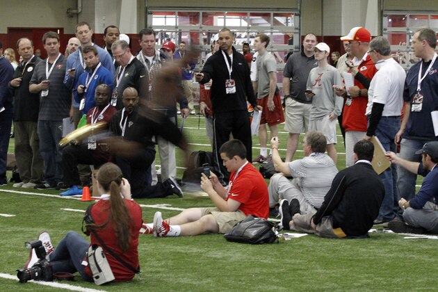 NFL scouts clock T.J. Yeldon as he runs the 40-yard dash at Alabama's Pro Day Wednesday, March 11, 2015, in Tuscaloosa, Ala. The event is to showcase players for the upcoming NFL football draft. (AP Photo/Butch Dill)