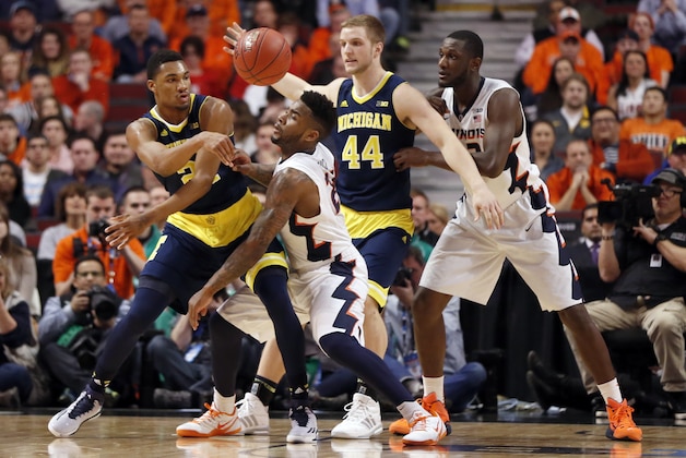 Michigan's Zak Irvin (21) passes the ball against Illinois' Rayvonte Rice (24) in the first half of an NCAA college basketball game in the second round of the Big Ten Conference tournament, Thursday, March 12, 2015, in Chicago. (AP Photo/Charles Rex Arbogast)