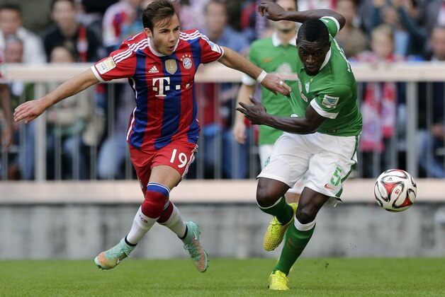 Bayern's Mario Goetze, left, and Bremen's Assani Lukimya from Congo challenge for the ball during the German first division Bundesliga soccer match between FC Bayern and SV Werder Bremen in the Allianz Arena in Munich, Germany, on Saturday, Oct. 18, 2014. (AP Photo/Matthias Schrader)