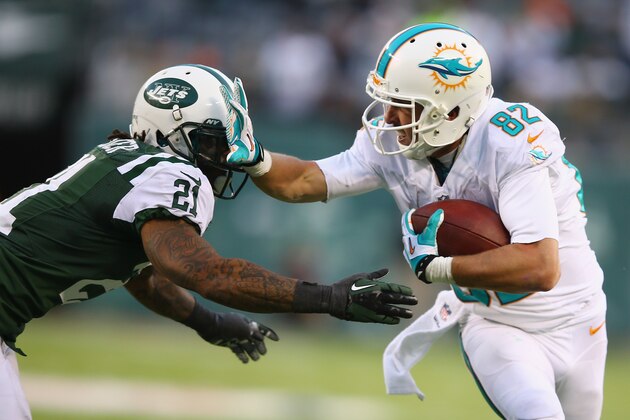 EAST RUTHERFORD, NJ - DECEMBER 01:   Brian Hartline #82 of the Miami Dolphins stiff arms  Ellis Lankster #21 of the New York Jets during their game at MetLife Stadium on December 1, 2013 in East Rutherford, New Jersey.  (Photo by Al Bello/Getty Images)