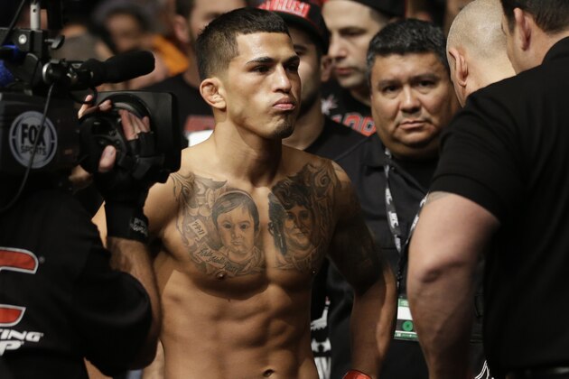 FILE - In this Jan. 26, 2013,  file photo, Anthony Pettis, center, checks waits before fighting Donald Cerrone in the UFC Lightweight Championship in Chicago. Pettis wants to be the biggest star in mixed martial arts, and the UFC's lightweight champion knows he has to stay busy to do it. Three months after ending a lengthy injury absence with his first title defense, Pettis is back in the cage at UFC 185 against Brazil's Rafael Dos Anjos on Saturday, March 14, in Dallas. (AP Photo/Nam Y. Huh,File)