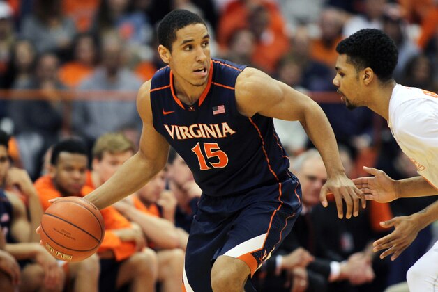 Virginia’s Malcolm Brogdon, left, dribbles around Syracuse’s Michael Gbinije, right, in the second half of an NCAA college basketball game in Syracuse, N.Y., Monday, March 2, 2015. Virginia won 59-47. (AP Photo/Nick Lisi)