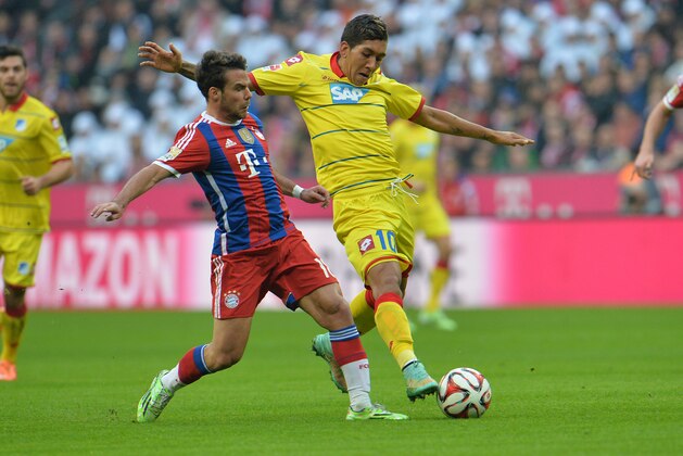 Bayern's Juan Bernat, left, and Hoffenheim's Roberto Firmino from Brazil challenge for the ball during the  soccer match between FC Bayern Munich and 1899 Hoffenheim in the Allianz Arena in Munich, Germany, on Saturday, Nov. 22, 2014. (AP Photo/Kerstin Joensson)