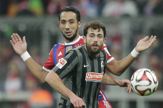 Freiburg's Admir Mehmedi from Switzerland, foreground, and Bayern’s Mehdi Benatia from Morocco challenge for the ball during the German first division Bundesliga soccer match between FC Bayern and SC Freiburg in the Allianz Arena in Munich, Germany, on Tuesday, Dec. 16, 2014. (AP Photo/Matthias Schrader)