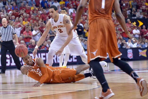 Mar 12, 2015; Kansas City, MO, USA; Texas Longhorns forward Jonathan Holmes (10) passes the ball as he's falling in the game against the Iowa State Cyclones during the first round at Sprint Center. Iowa State Cyclones won 69-67.  Mandatory Credit: Denny Medley-USA TODAY Sports