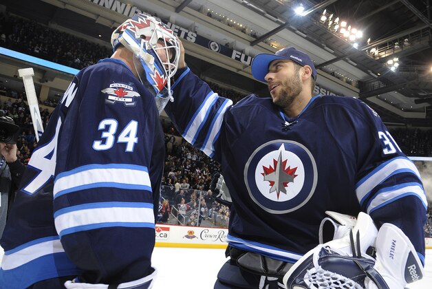 WINNIPEG, CANADA - MARCH 1: Goaltender Michael Hutchinson #34 of the Winnipeg Jets gets congratulated by teammate Ondrej Pavelec #31 after backstopping the Jets to a 5-2 victory over the Los Angeles Kings on March 1, 2015 at the MTS Centre in Winnipeg, Manitoba, Canada.  (Photo by Lance Thomson/NHLI via Getty Images)