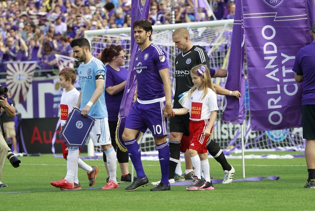 Mar 8, 2015; Orlando, FL, USA; Orlando City FC midfielder Kaka (10) and New York City FC forward David Villa (7) takes with field with youth soccer players prior to the game at Orlando Citrus Bowl Stadium. Mandatory Credit: Kim Klement-USA TODAY Sports
