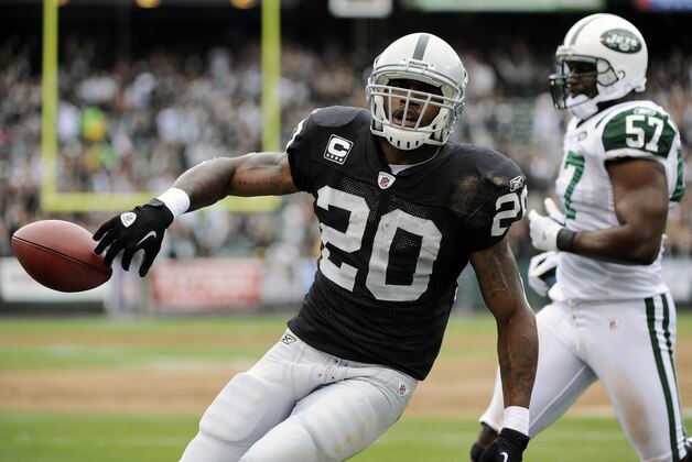 OAKLAND, CA - SEPTEMBER 25: Darren McFadden #20 of the Oakland Raiders tosses the ball away after scoring on a two yard touchdown run against the New York Jets in the first quarter during an NFL football game at the O.co Coliseum September 25, 2011 in Oakland, California.  (Photo by Thearon W. Henderson/Getty Images)