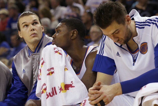 New York Knicks forward Lou Amundson, left, sits on the bench with forward Cleanthony Early and center Andrea Bargnani, right, during the second half of an NBA basketball game against the Golden State Warriors in Oakland, Calif., Saturday, March 14, 2015. The Warriors won 125-94. (AP Photo/Jeff Chiu)