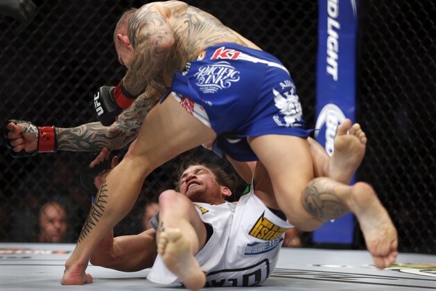 Ross Pearson delivers a blow to Sam Stout, of Canada, during a men's lightweight UFC bout, Saturday, March 14, 2015, in Dallas. Pearson won the match in a two-round TKO. (AP Photo/Brandon Wade)
