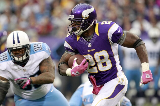FILE - In this Oct. 7, 2012, file photo, Minnesota Vikings running back Adrian Peterson, right, wearing pink for breast cancer awarenes, runs from Tennessee Titans defensive tackle Jurrell Casey, left, during the first half of an NFL football game in Minneapolis. Some would say the league is at a moral crossroads as focus on abuse allegations against players and the their response to them intensifies. Some women have been among the most vocal NFL detractors. Yet female NFL fans, who are stinking mad about the abuse and the way the league has handled it, continue to watch. The NFL has started female fan groups and has made a big push for breast cancer awareness in October, rolling out pink shoes, sweatbands and jerseys. (AP Photo/Genevieve Ross, File)