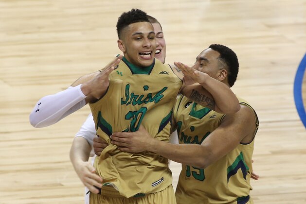 Notre Dame's Zach Auguste (30) celebrates with teammate after an NCAA college basketball game against North Carolina in the championship of the Atlantic Coast Conference tournament in Greensboro, N.C., Saturday, March 14, 2015. Notre Dame won 90-82. (AP Photo/Bob Jordan)