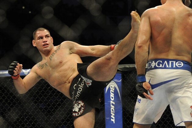 UFC heavyweight champion Cain Velasquez, left, delivers a kick to Junior Dos Santos in a fight for the UFC World Heavyweight title in Houston, Saturday, Oct. 19, 2013. (AP Photo/Pat Sullivan)