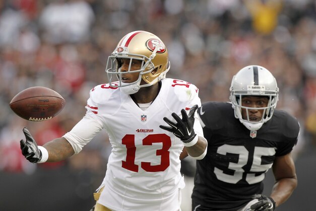 Dec 7, 2014; Oakland, CA, USA; San Francisco 49ers wide receiver Stevie Johnson (13) is unable to make a catch in front of Oakland Raiders defensive back Chimdi Chekwa (35) in the second quarter at O.co Coliseum. Mandatory Credit: Cary Edmondson-USA TODAY Sports