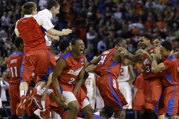 Dayton's Kendall Pollard (22) and Jordan Sibert (24) celebrate with teammates after a second-round game against Ohio State in the NCAA college basketball tournament in Buffalo, N.Y., Thursday, March 20, 2014. Dayton won the game 60-59. (AP Photo/Frank Franklin II)